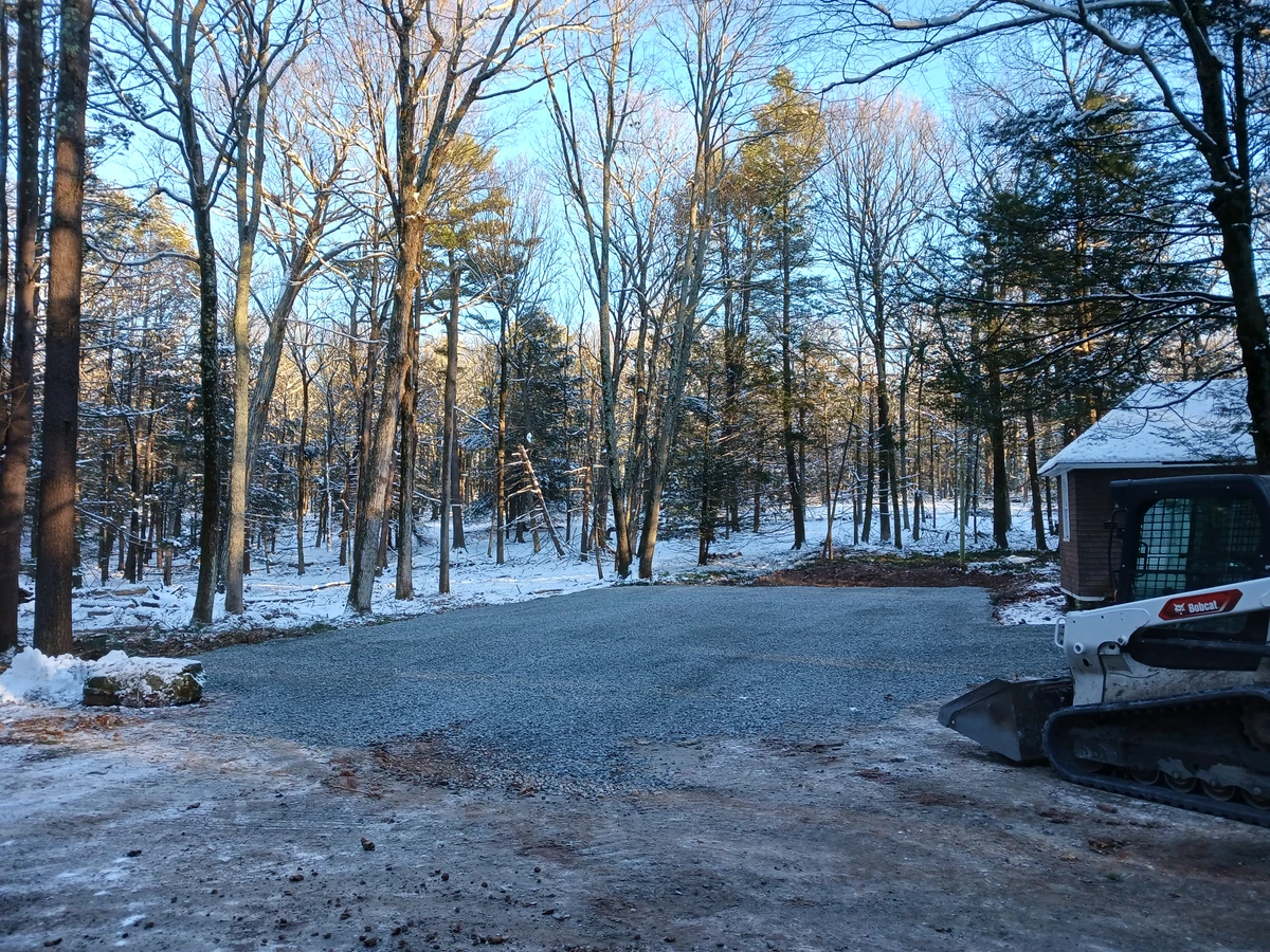 Newly installed stone driveway through a wooded property